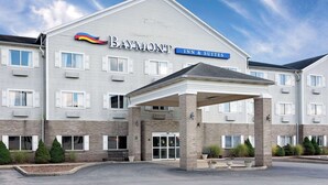 Un Baymont Inn & Suites con entrada cubierta, varias ventanas y fachada de ladrillo.
