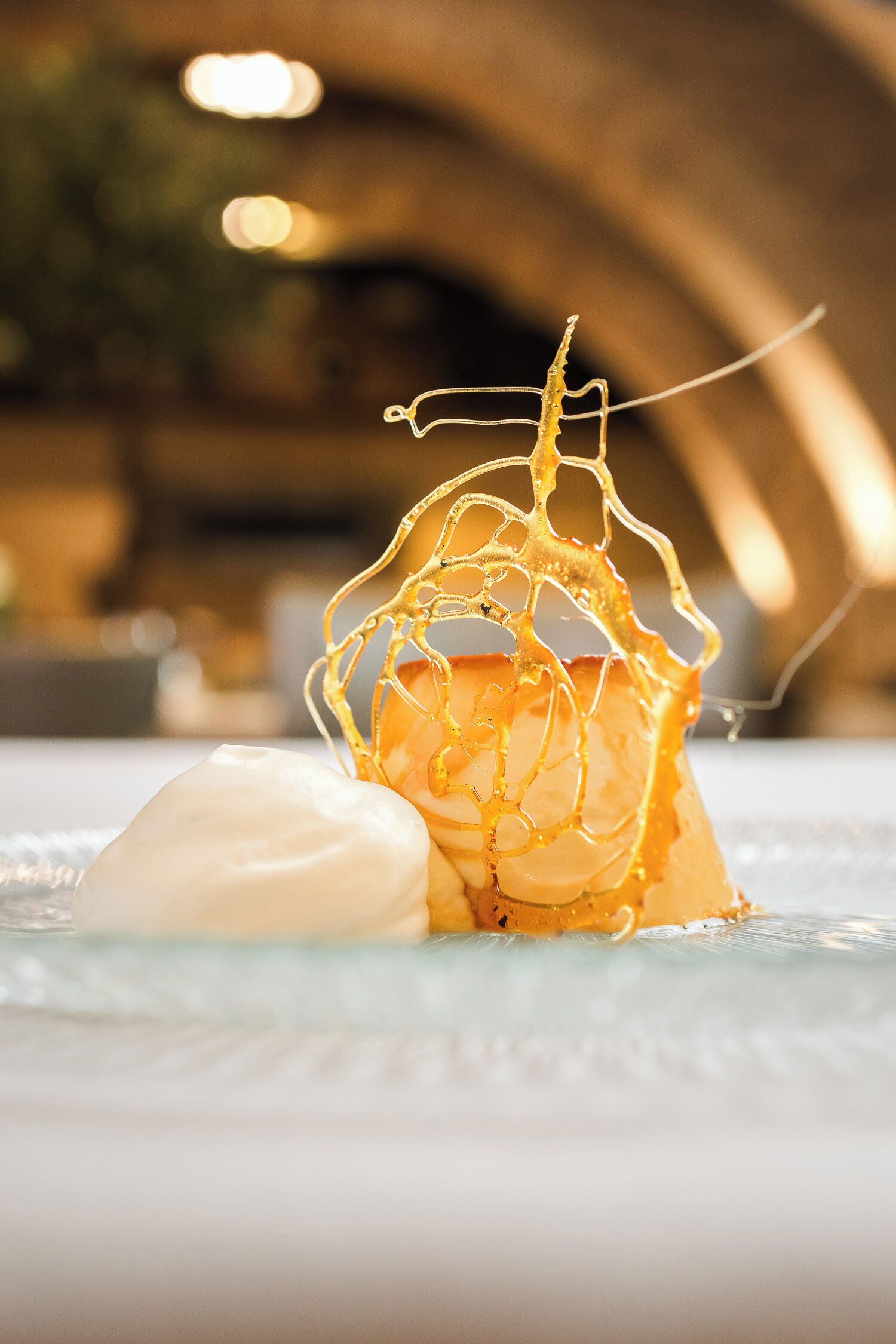 Un postre con un diseño dorado y elaborado sobre un plato blanco.