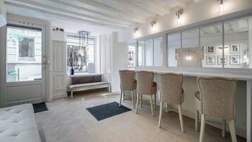 Un intérieur moderne avec un banc, des tabourets de bar et un grand miroir.