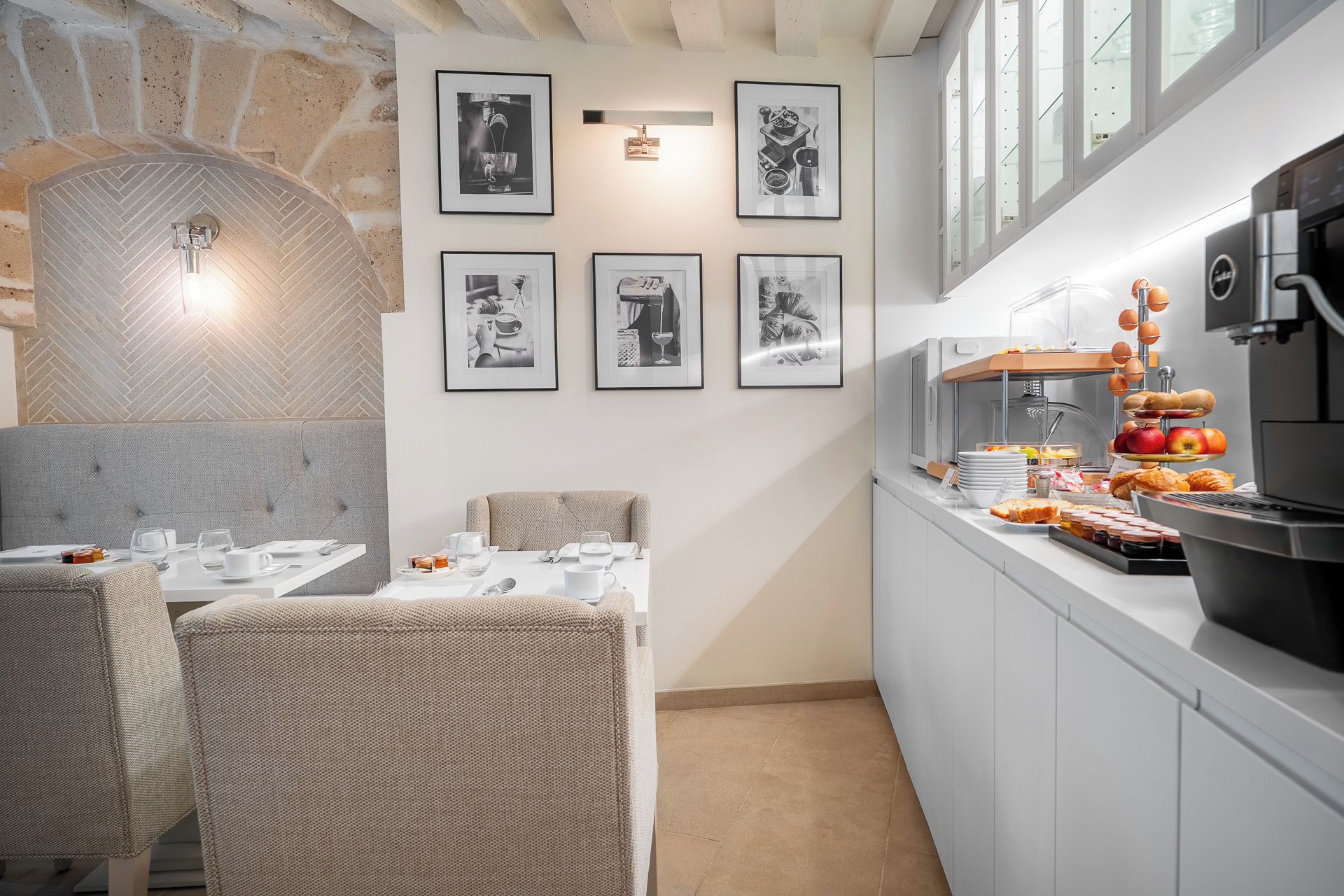 Un comedor con pared de piedra, un bufé con alimentos y fotografías enmarcadas en la pared.