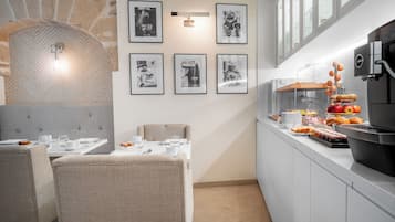 Un comedor con pared de piedra, un bufé con alimentos y fotografías enmarcadas en la pared.