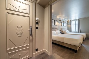 A hotel room with a large bed, two bedside tables, a wardrobe, and a door with a decorative handle. - Hôtel Villa d'Estrées - Saint-Germain (Paris)