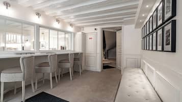 Un baño moderno con un espejo grande, una tocador y un banco.