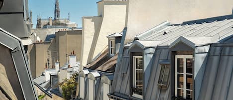 A row of buildings with multiple rooftops, including a prominent church spire in the background.