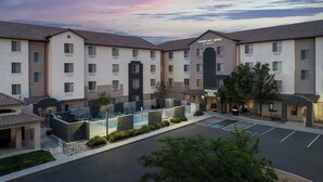A hotel with a courtyard, outdoor seating, and a swimming pool. - Towneplace Suites Abq Airport (Albuquerque)