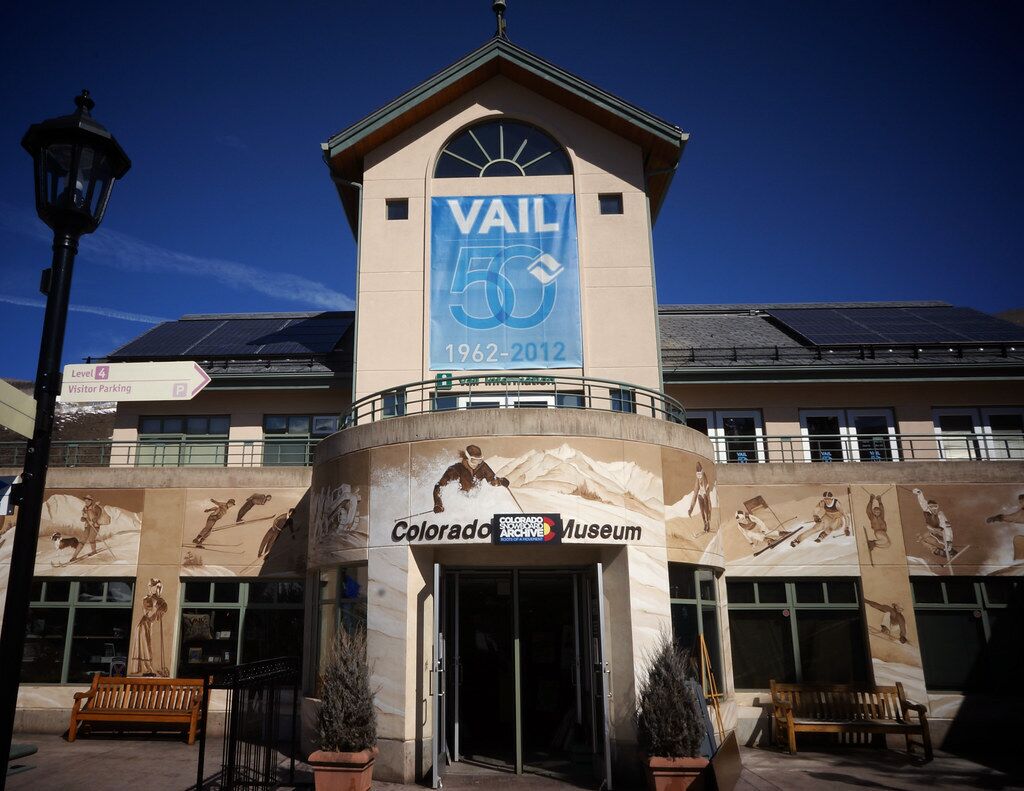 Das Gebäude des Colorado Museums mit einem Schild 'VAIL 50' und einem Schild für 'Besucherparkplätze'.