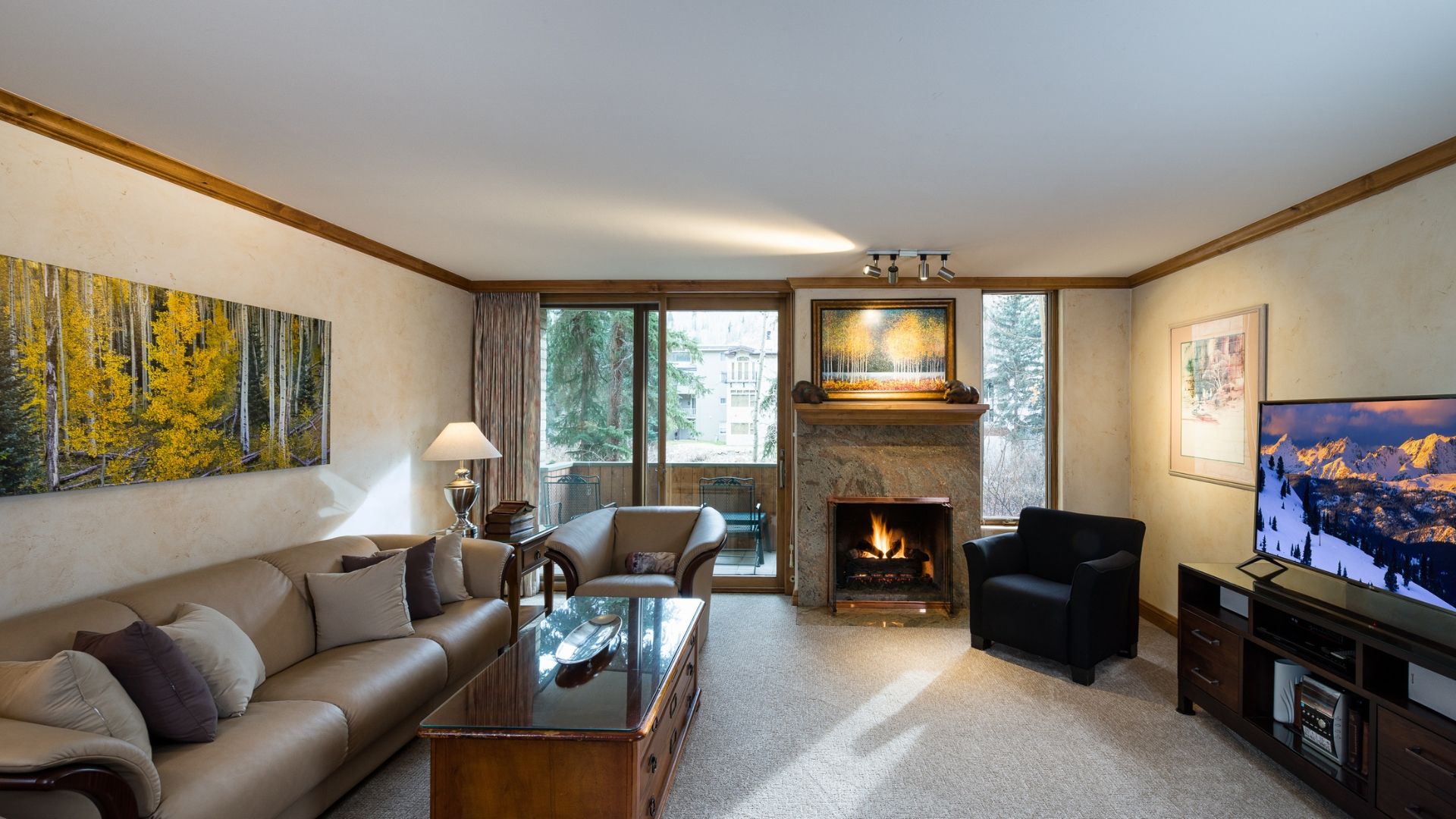 A living room with a fireplace, a sofa, a coffee table, and a television.