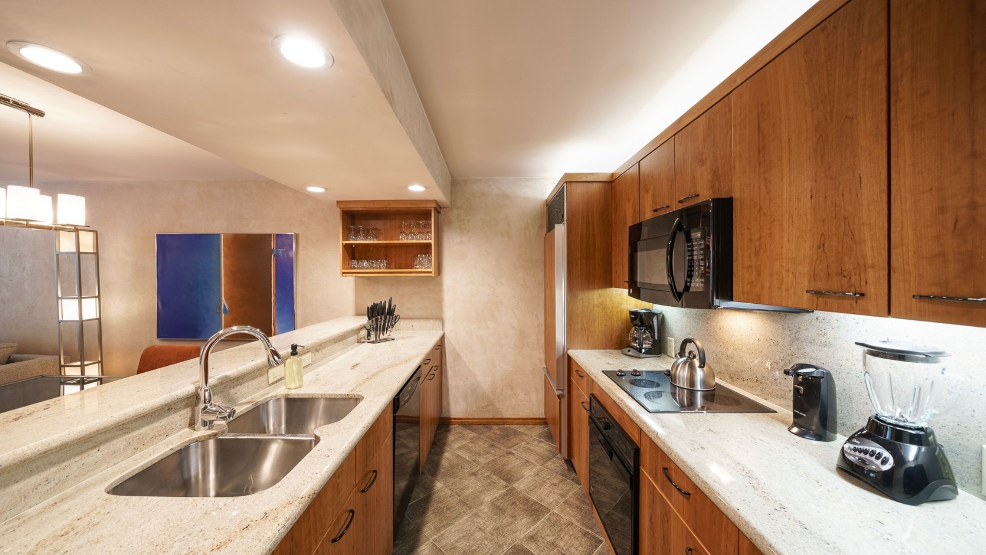 A modern kitchen with stainless steel appliances, wooden cabinets, and a granite countertop.