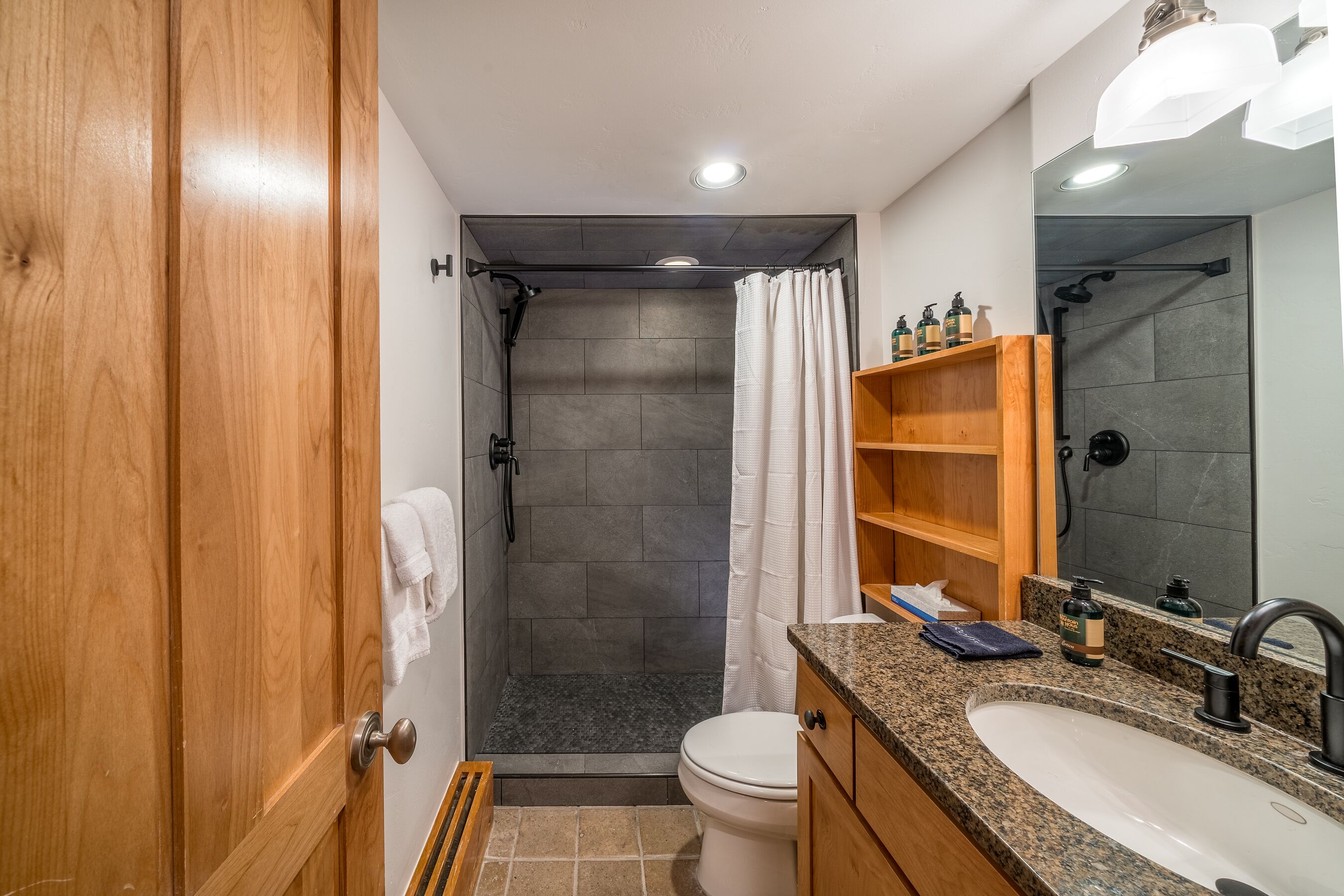 Un baño moderno con ducha, inodoro y lavamanos.