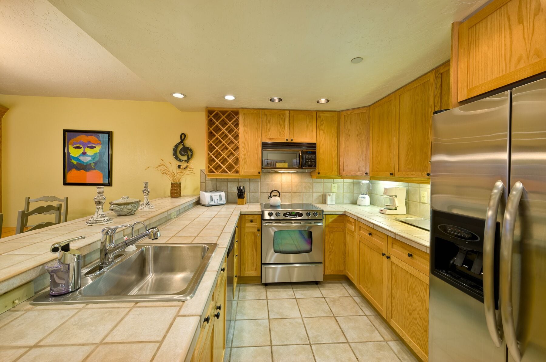A modern kitchen with wooden cabinets, stainless steel appliances, and a tiled backsplash.
