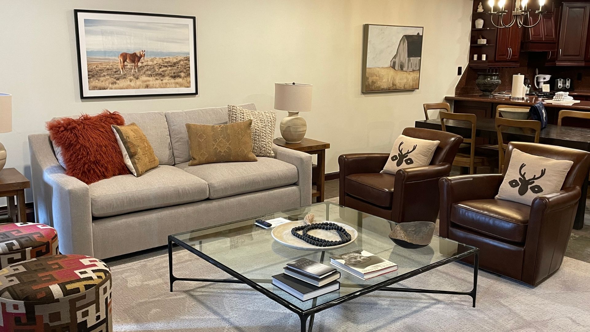 Un salon comprenant un canapé, des fauteuils, une table basse et un coin repas avec des chaises et une table.