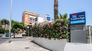 Wegwijzer voor Hoteles Travelodge Alicante Puerto met aanduidingen naar de receptie, parkeerplaats en het restaurant.