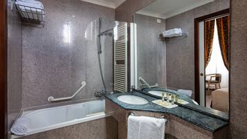 Un bagno con una vasca, due lavandini, uno specchio e un portasciugamani.