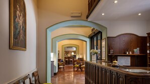 A hotel lobby with a reception desk, seating area, and a staircase. - Hotel Fontebella (Assisi)