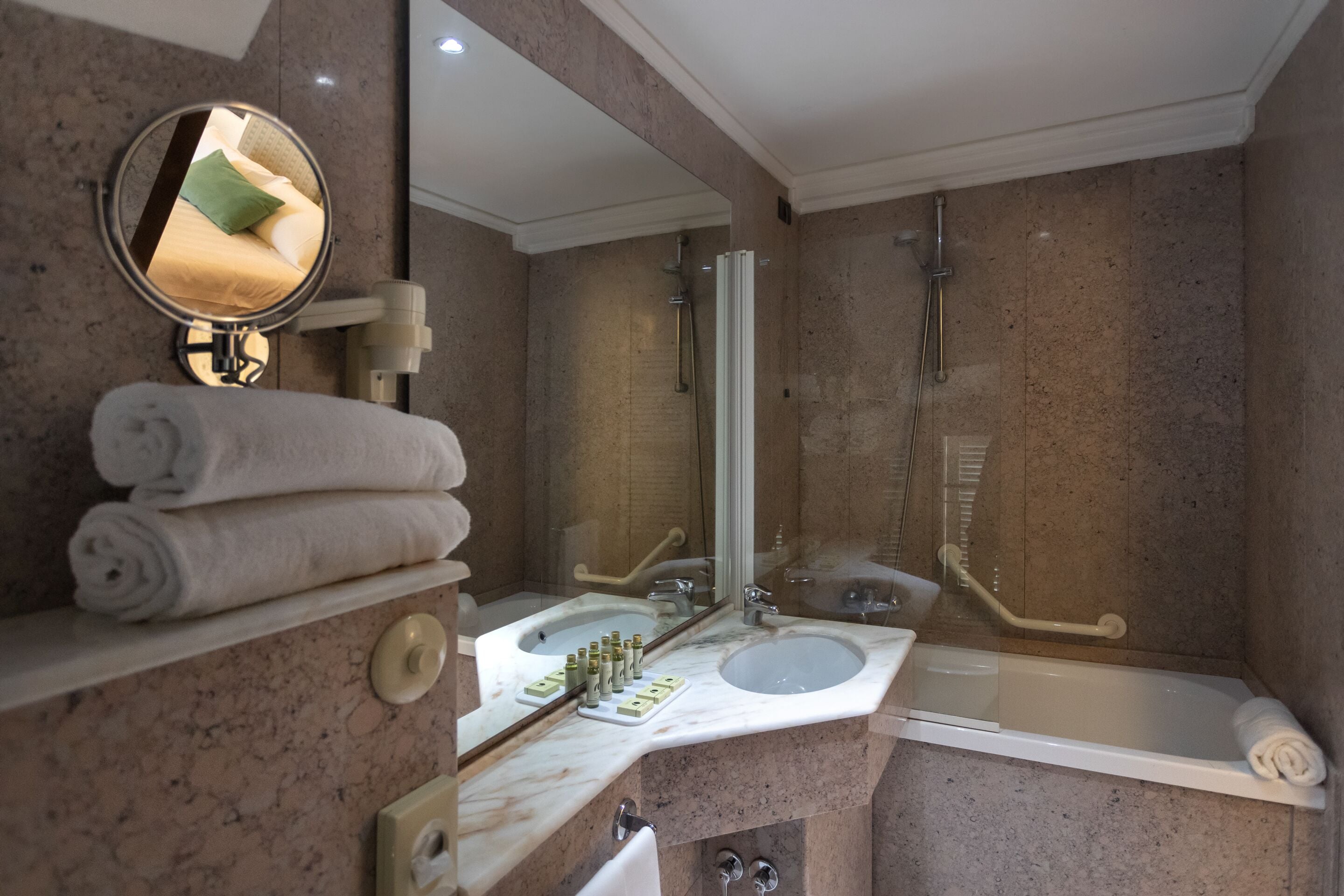 A modern bathroom with a marble sink, a bathtub, and a shower.
