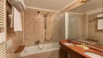 A bathroom with a bathtub, a shower, and two sinks.