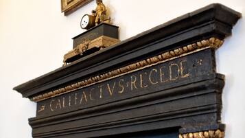 A fireplace with a decorative plaque reading "CALLEFACTVS RECEDE".