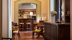 A bar area with wooden furniture, a bar counter, and a selection of bottles and glasses. - Hotel Fontebella (Assisi)