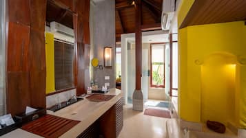 A modern kitchen with wooden accents, a yellow accent wall, and a view to the outside.