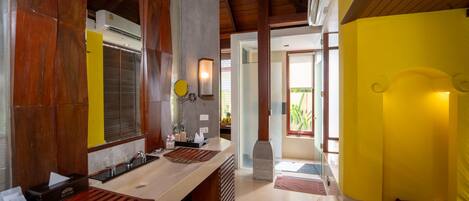 A modern kitchen with wooden accents, a yellow accent wall, and a view to the outside.