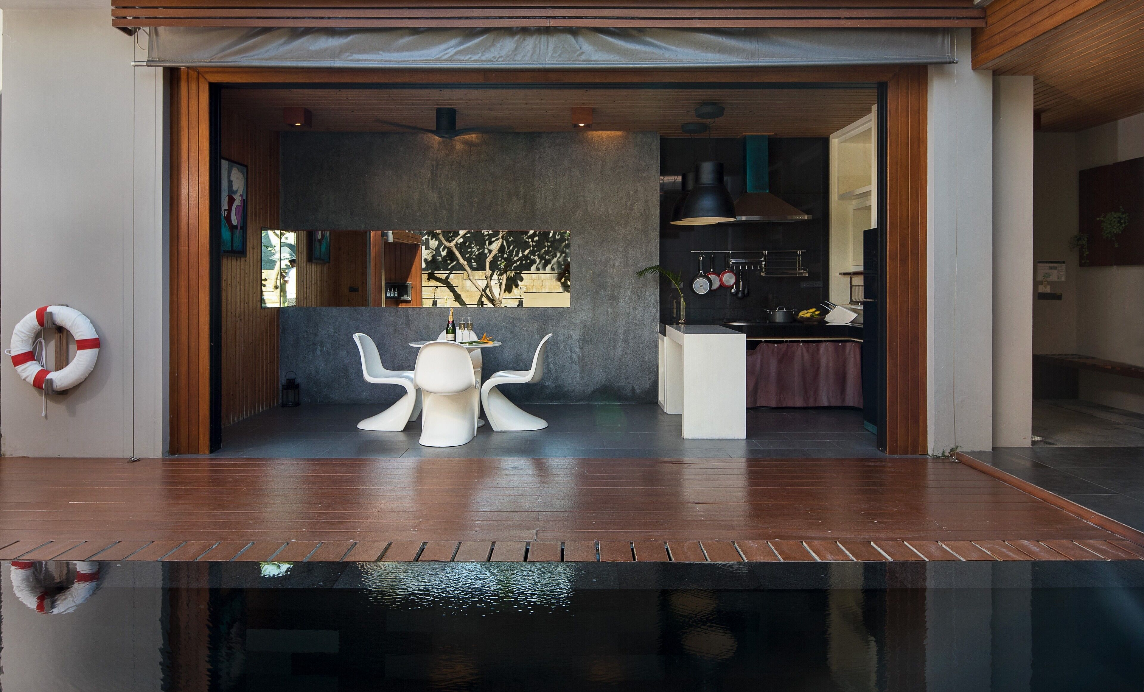 A modern interior with a dining area, kitchen, and a pool.