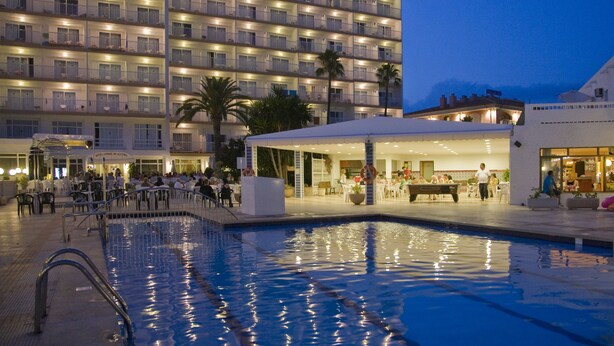 Ein Hotel mit mehreren Balkonen, einem Schwimmbad und Außenbereich-Sitzgelegenheiten.