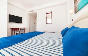 A hotel room with a bed, a flat-screen TV, a desk, and a mirror. - Globales Condes de Alcudia (Alcúdia)
