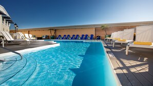 A swimming pool with blue water, surrounded by lounge chairs and sun loungers. - Kemah Boardwalk Inn (Kemah)