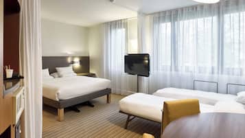 A hotel room with a bed, a TV, a desk, and a chair.