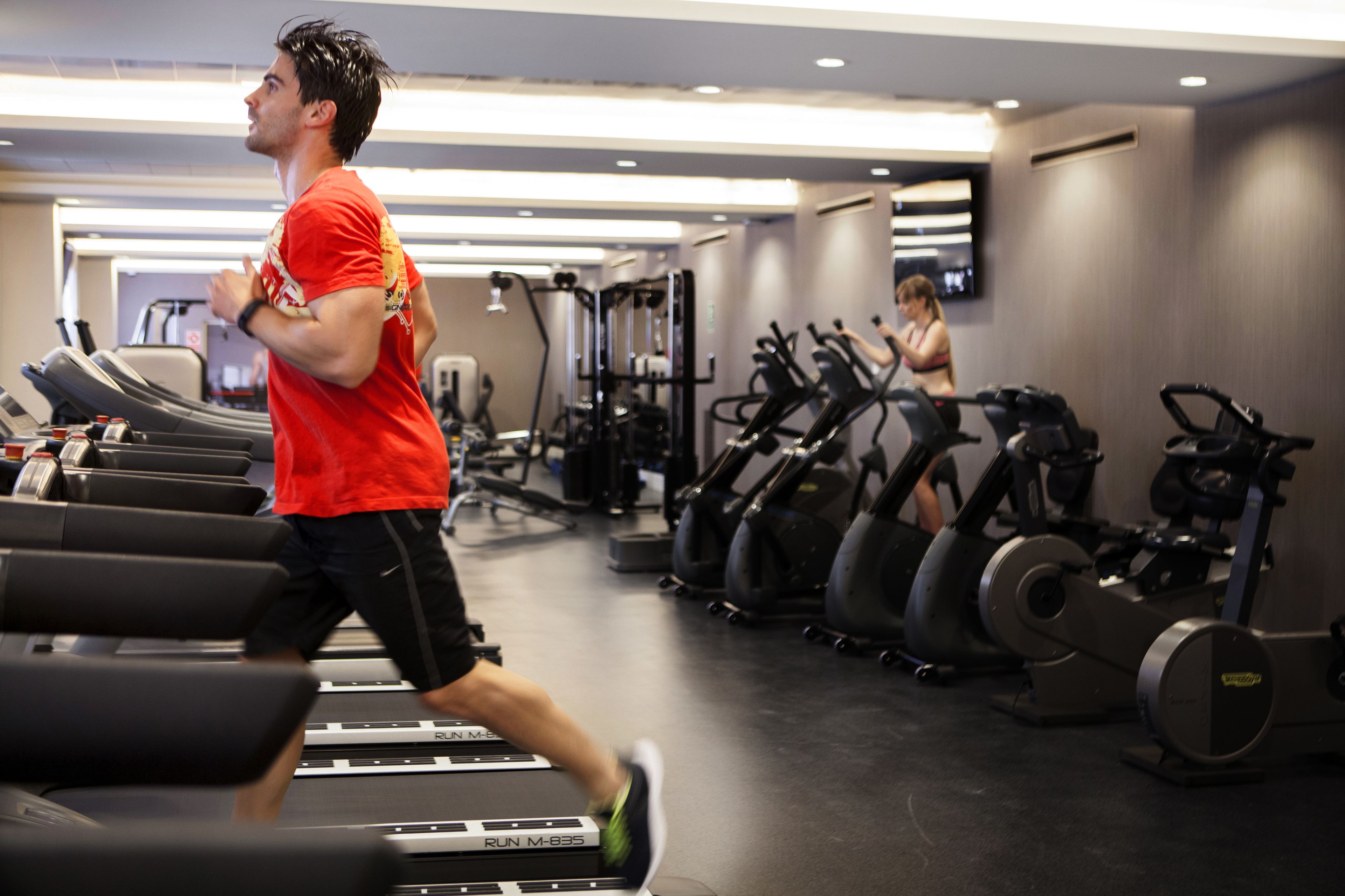 Une salle de sport équipée de tapis de course, de vélos d’appartement et d’appareils de musculation.