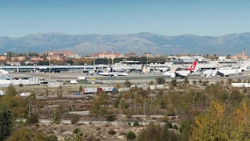 An airport with multiple aircraft, including a Ryanair plane, and a mountainous backdrop.