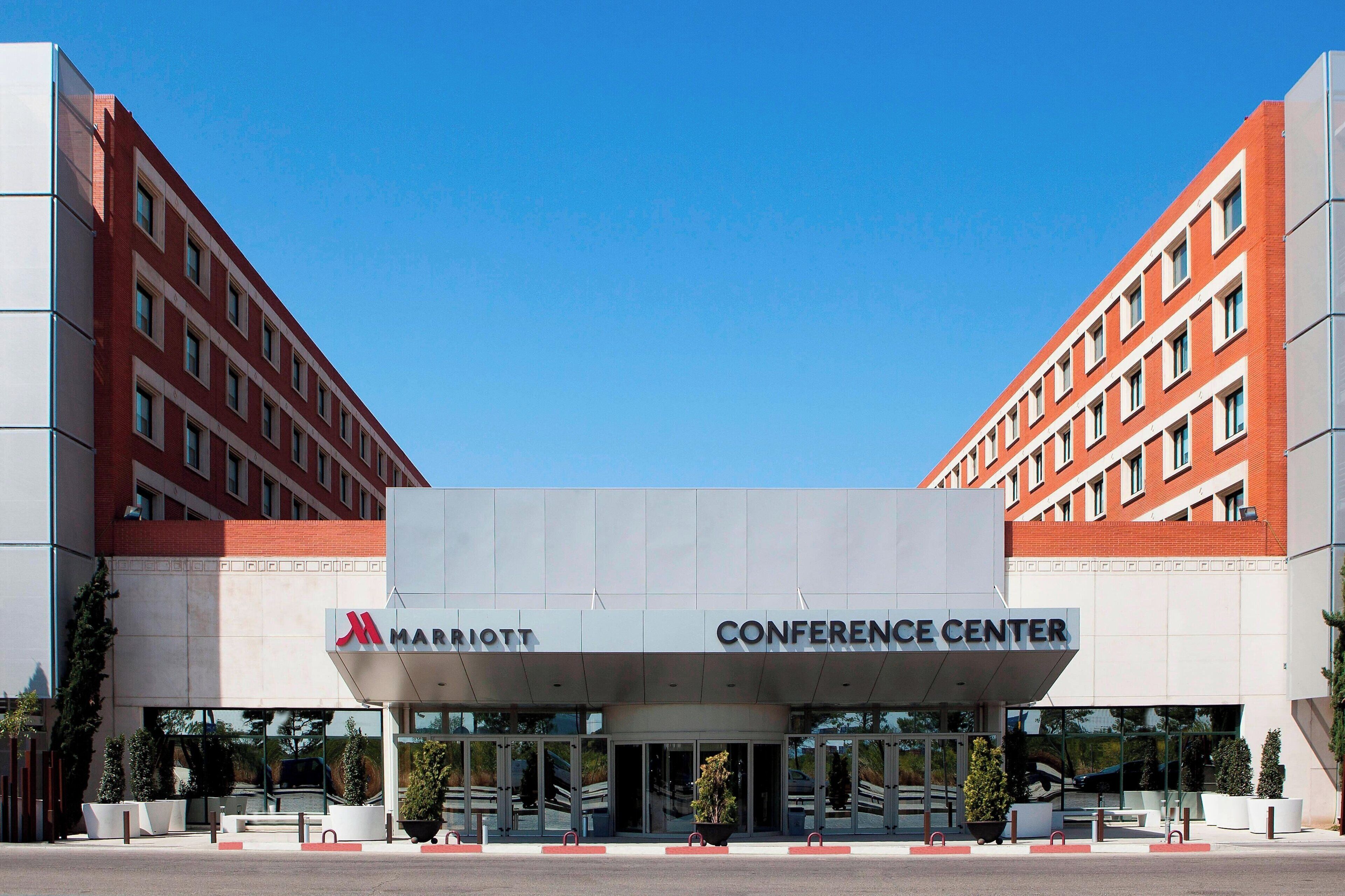 A Marriott Conference Center with a modern architectural design, featuring a prominent entrance and a clear sky above.