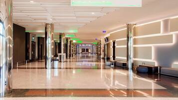 A modern hotel lobby with a long corridor, polished floors, and contemporary lighting fixtures.