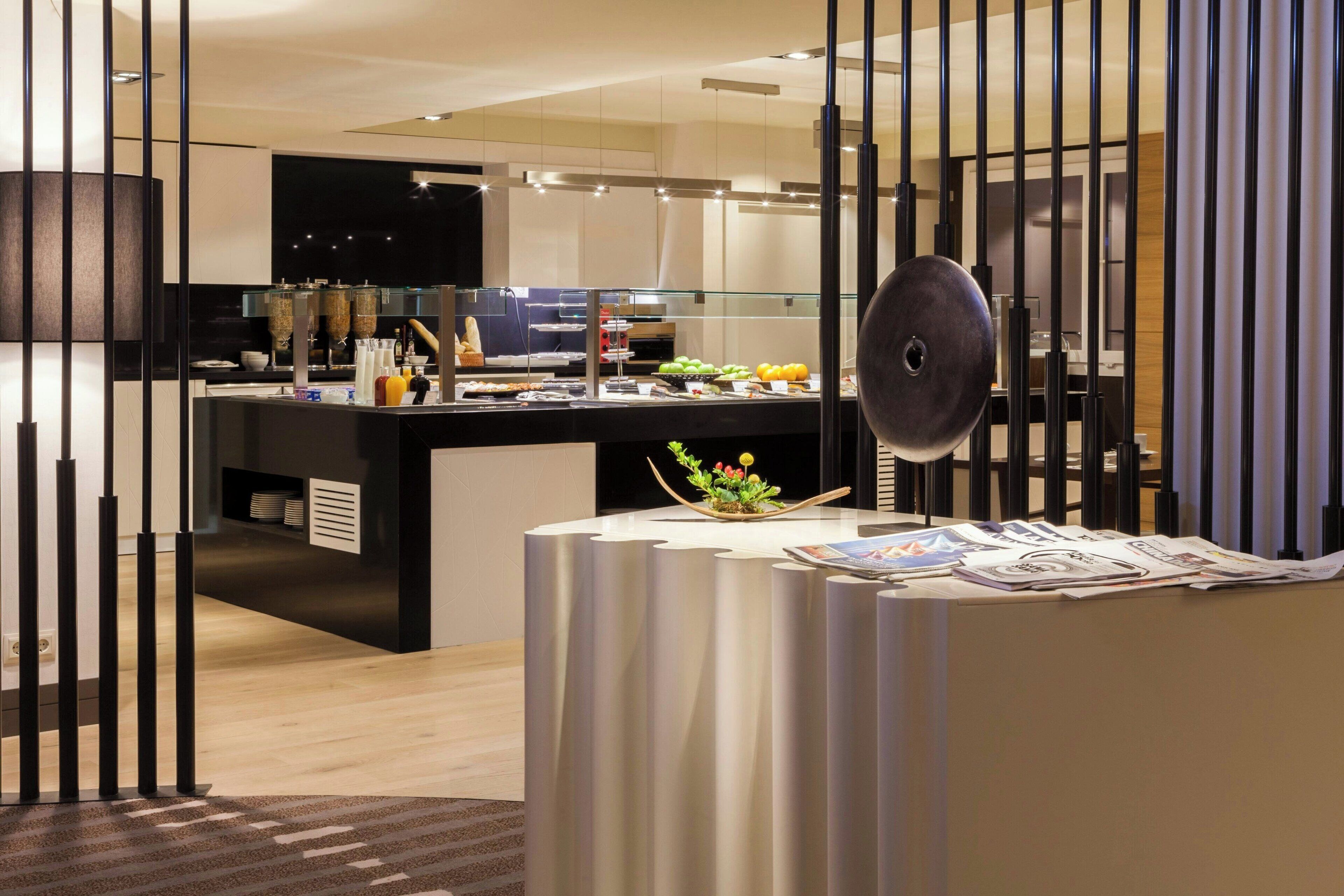 Une cuisine moderne dotée d’un îlot central, d’un coin repas avec une table ronde et d’une plante décorative.