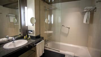 Un baño moderno con lavamanos doble, cabina de ducha con mampara de vidrio y bañera.
