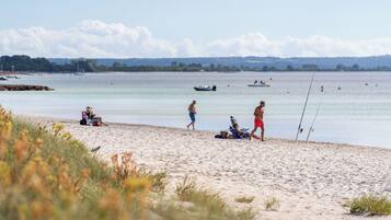 A beach with people relaxing and fishing.