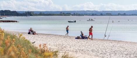 A beach with people relaxing and fishing.
