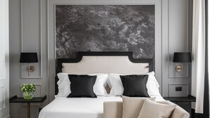 Een moderne slaapkamer met een groot bed, een bank en twee nachtkastjes.