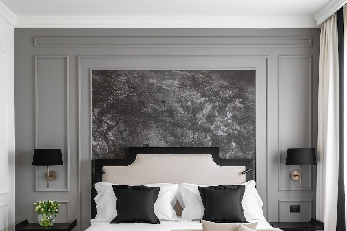 A modern bedroom with a large bed, a sofa, and two nightstands.