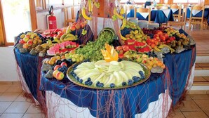 Une présentation de fruits sur un buffet, avec une variété de fruits et un centre de table décoratif.