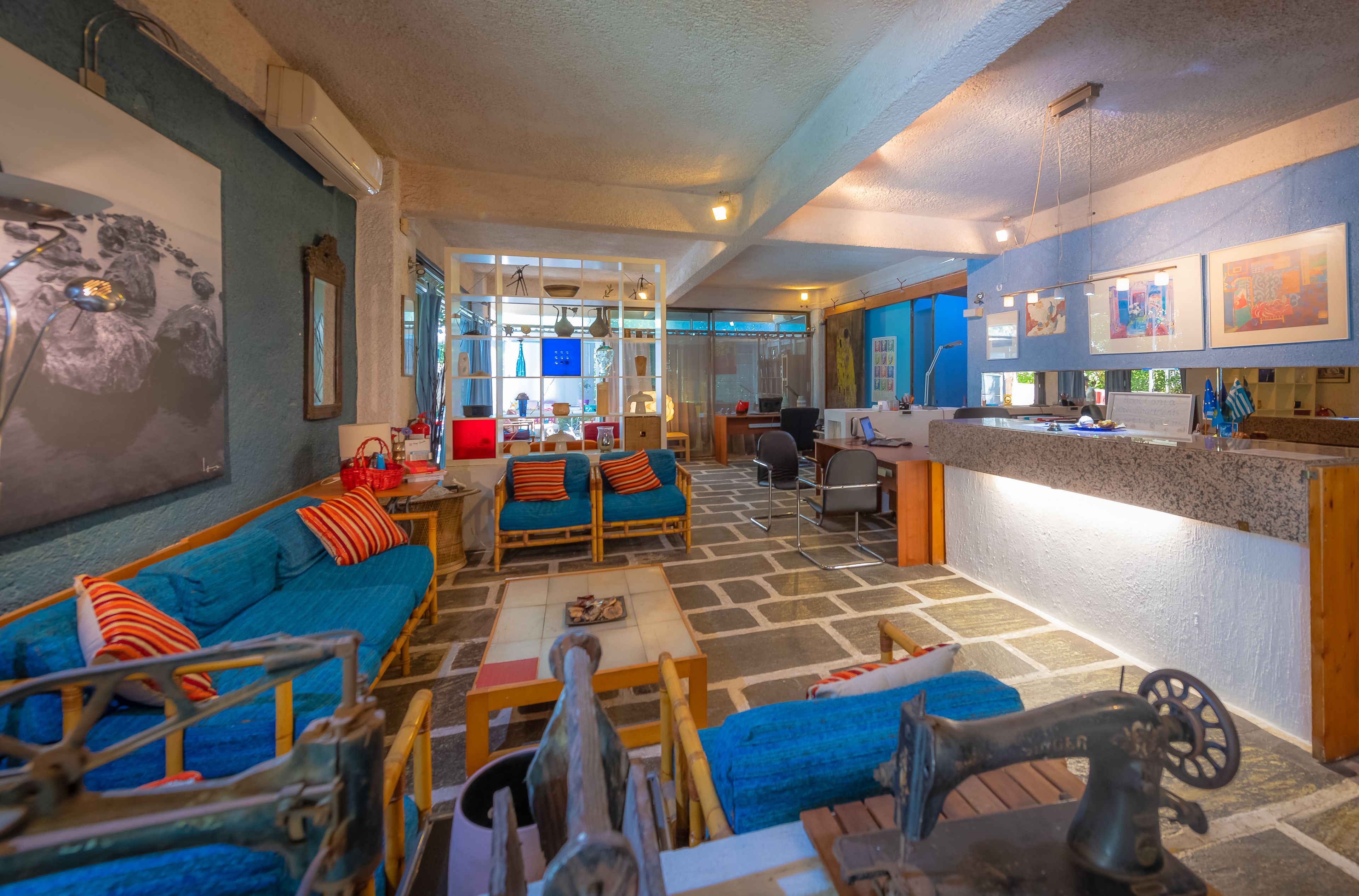 Un'ampia zona giorno con un divano blu, un tavolino da caffè e una macchina da cucire vintage.