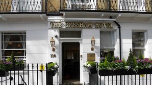 L’hôtel Gresham, avec sa façade blanche, son portail en fer noir et ses jardinières.