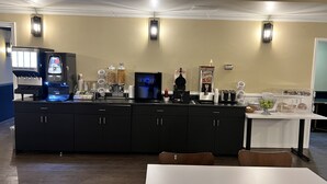 A breakfast bar with coffee machines, a waffle maker, and a fruit bowl. - Super 8 by Wyndham Kirkland Lake (Kirkland Lake)