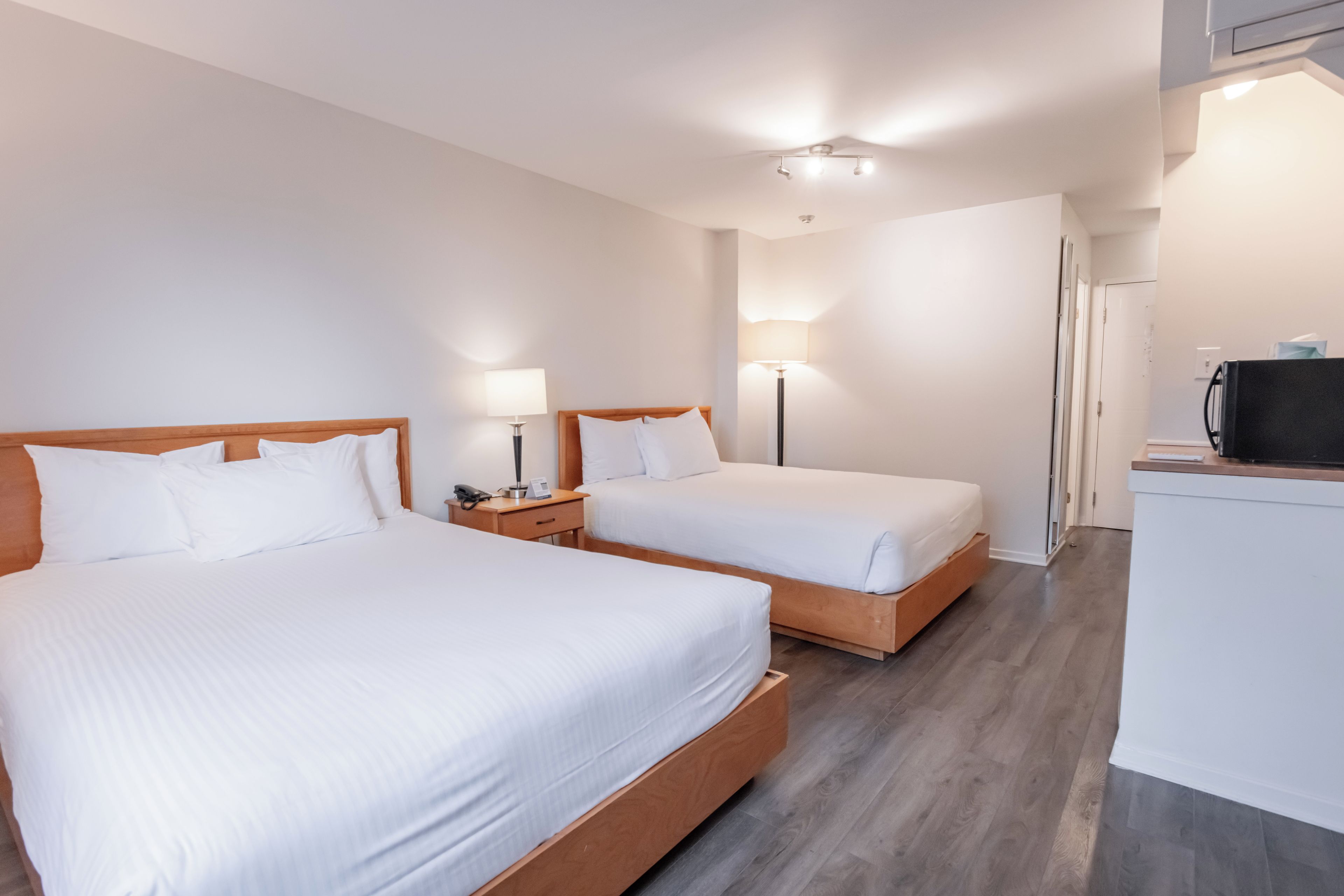 Hotellihuone, jossa on kaksi sänkyä, työpöytä ja taulutelevisio.