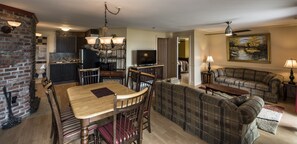 A spacious living area with a dining table, sofa, and a television.