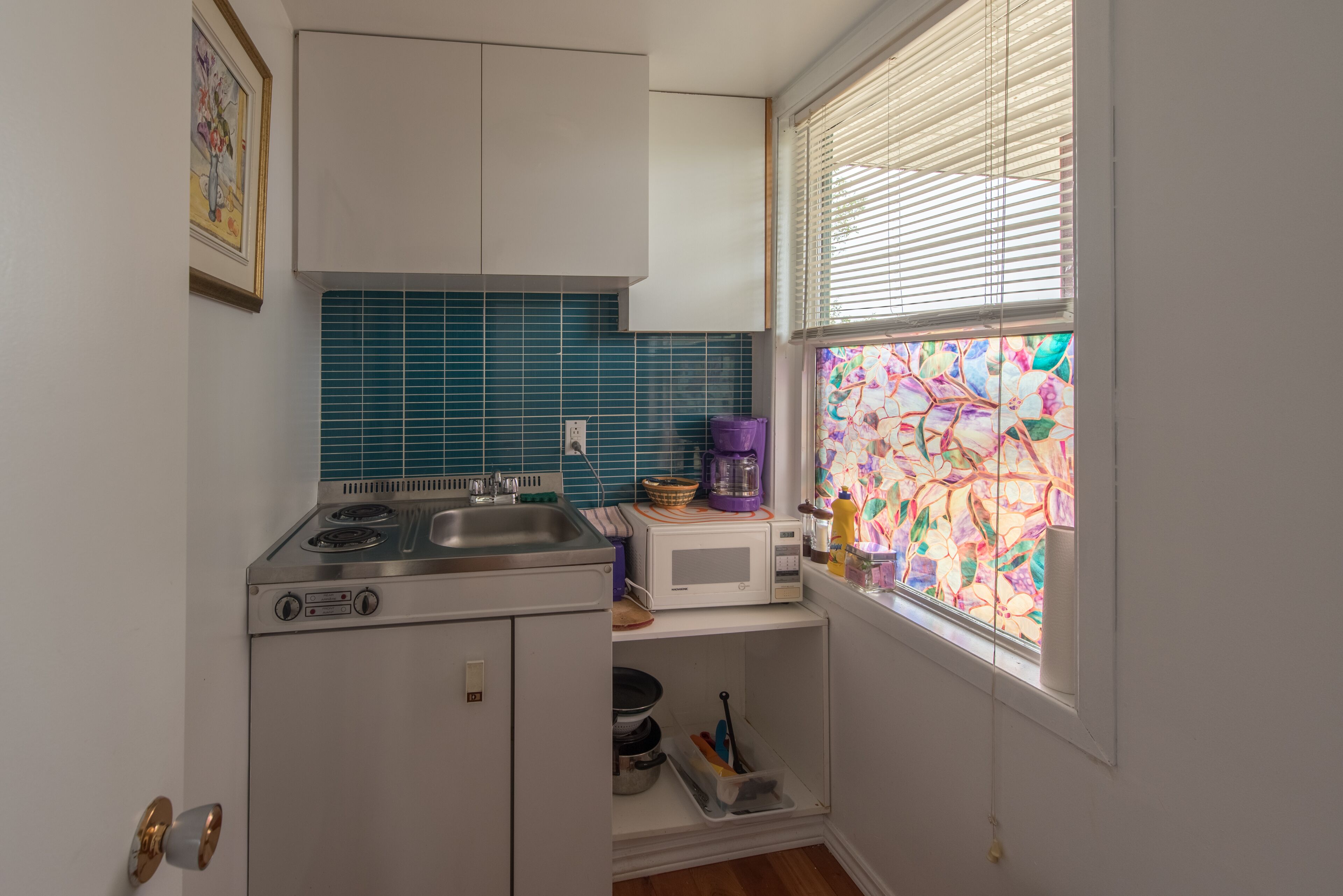 A compact kitchen with a gas stove, a microwave, and a sink.