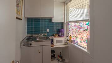 A compact kitchen with a gas stove, a microwave, and a sink.