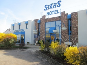 A Stars Hotel with a brick facade, blue accents, and a clear entrance. - Hotel Stars Dijon Sud (Chenove)