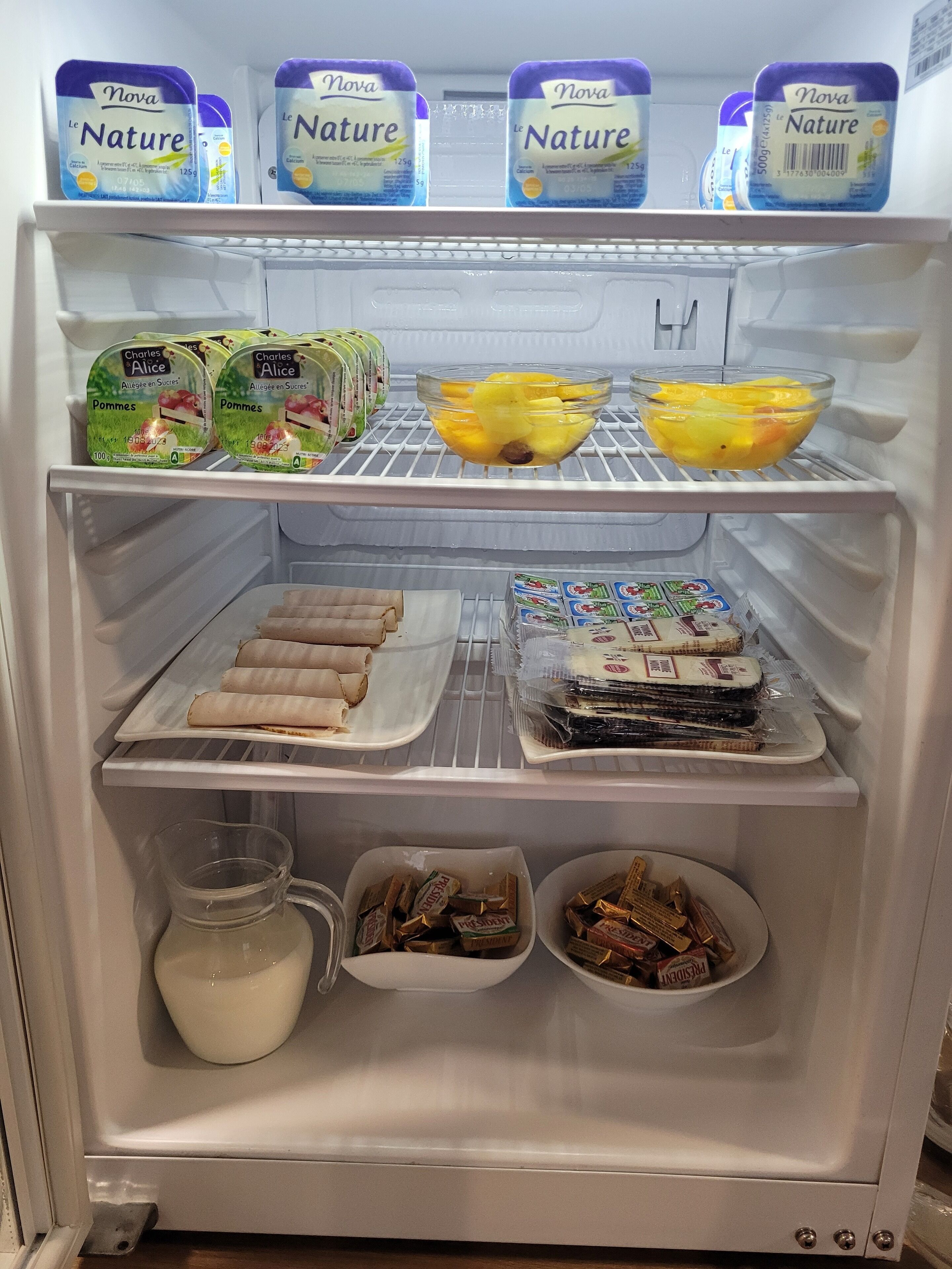 A refrigerator stocked with various food items including dairy products, fruits, and packaged goods.