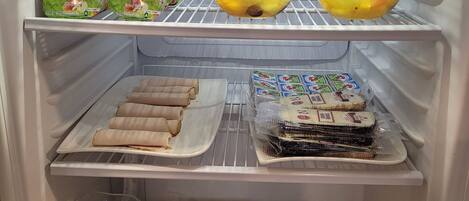 A refrigerator stocked with various food items including dairy products, fruits, and packaged goods.